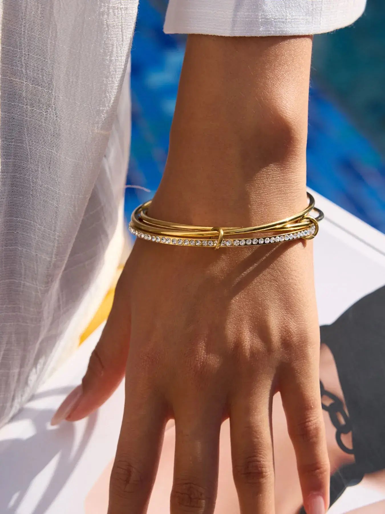 Close-up detail of tarnish-free gold infinity bracelet with pavé zircon accents.