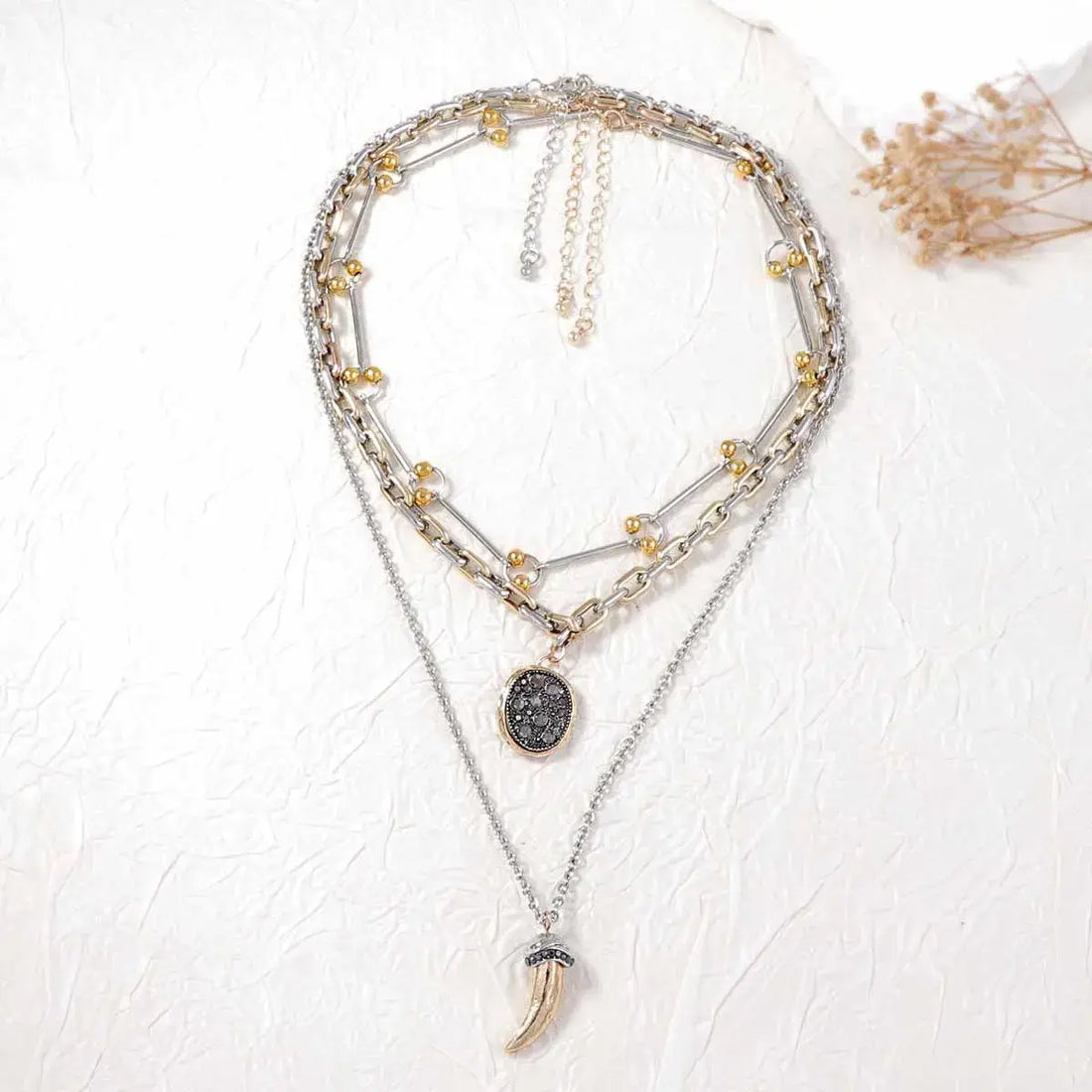 Multistrand necklace with pendant on a textured white surface